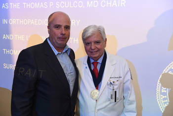 Andreas Dracopoulos, President of the Stavros Niarchos Foundation, takes a photo with a doctor wearing a medal